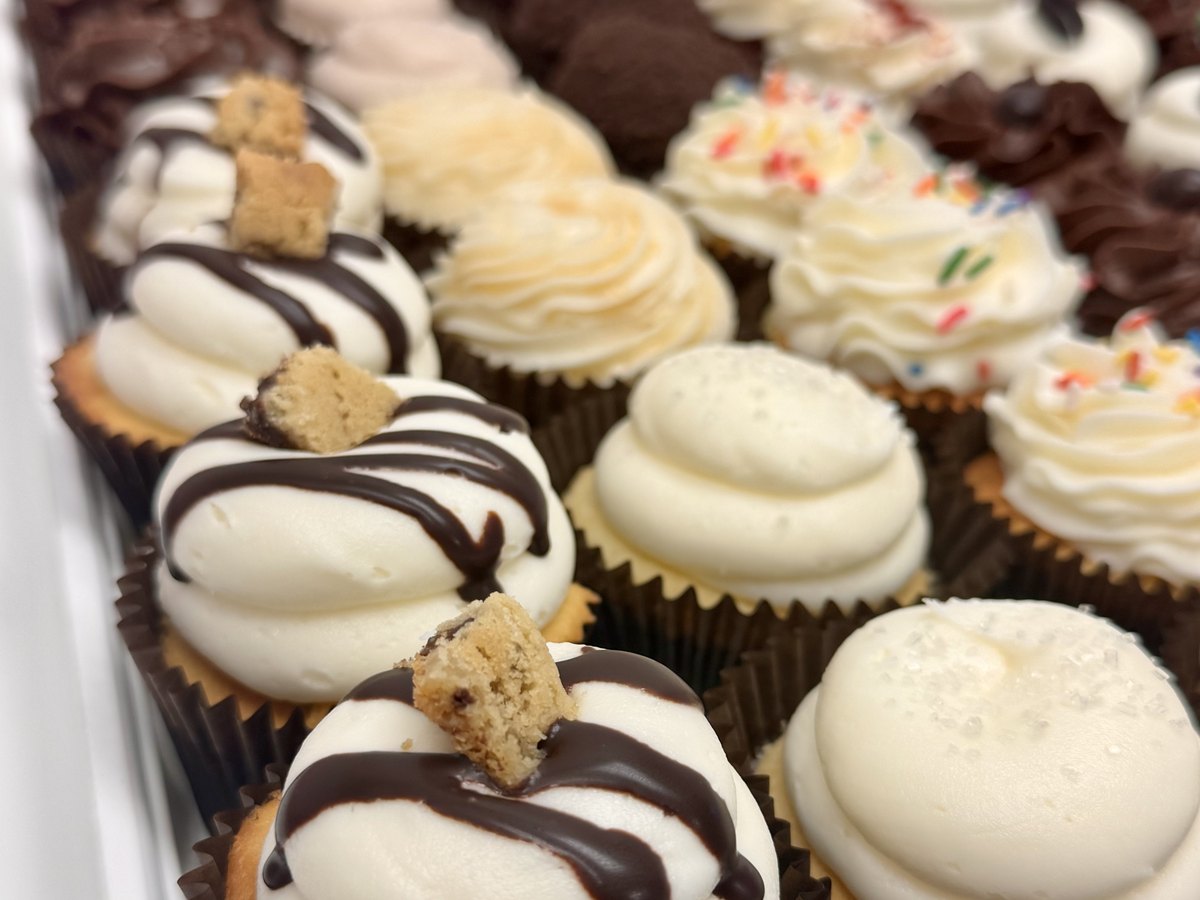 A tray of Mrs. Kelder's cupcakes in the case, buttercream, chocolate and sprinkles