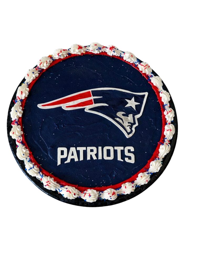 A cookie cake iced with a football team crest on navy, with a red and white border