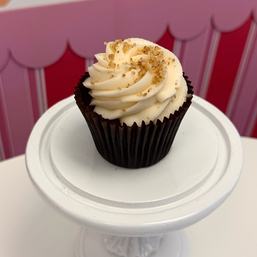 A cupcake with buttercream and a golden crumble topping