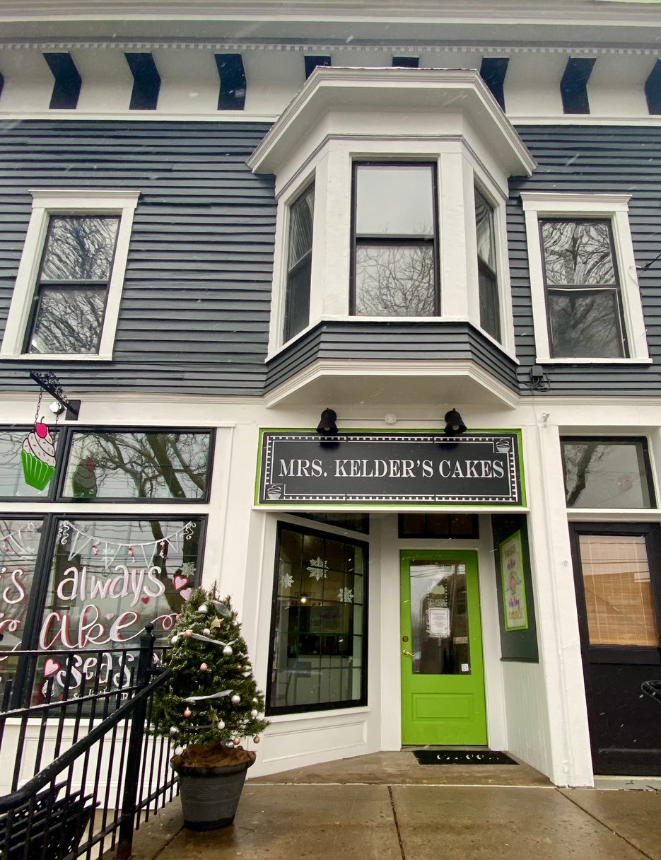 The shop in 2022, repainted grey with a bright green door