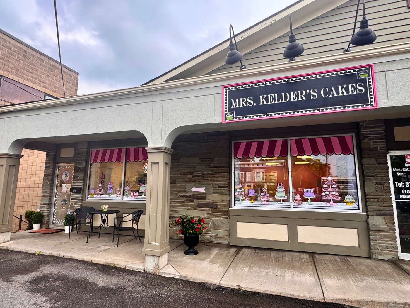 The new shop in 2026, with pink striped awnings under a stone arcade