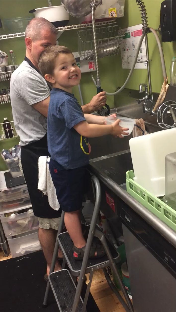 Washing up at the dish room sink with a little helper on a step stool