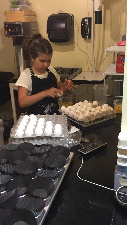 A young helper with trays of eggs in the shop kitchen