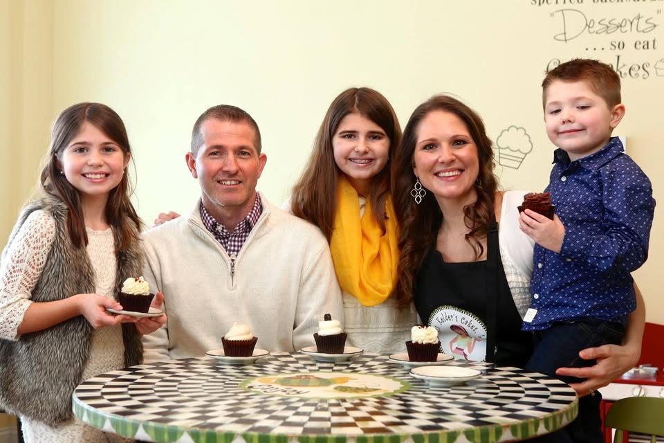 The Kelder family at a checkered table in the shop, each holding a cupcake