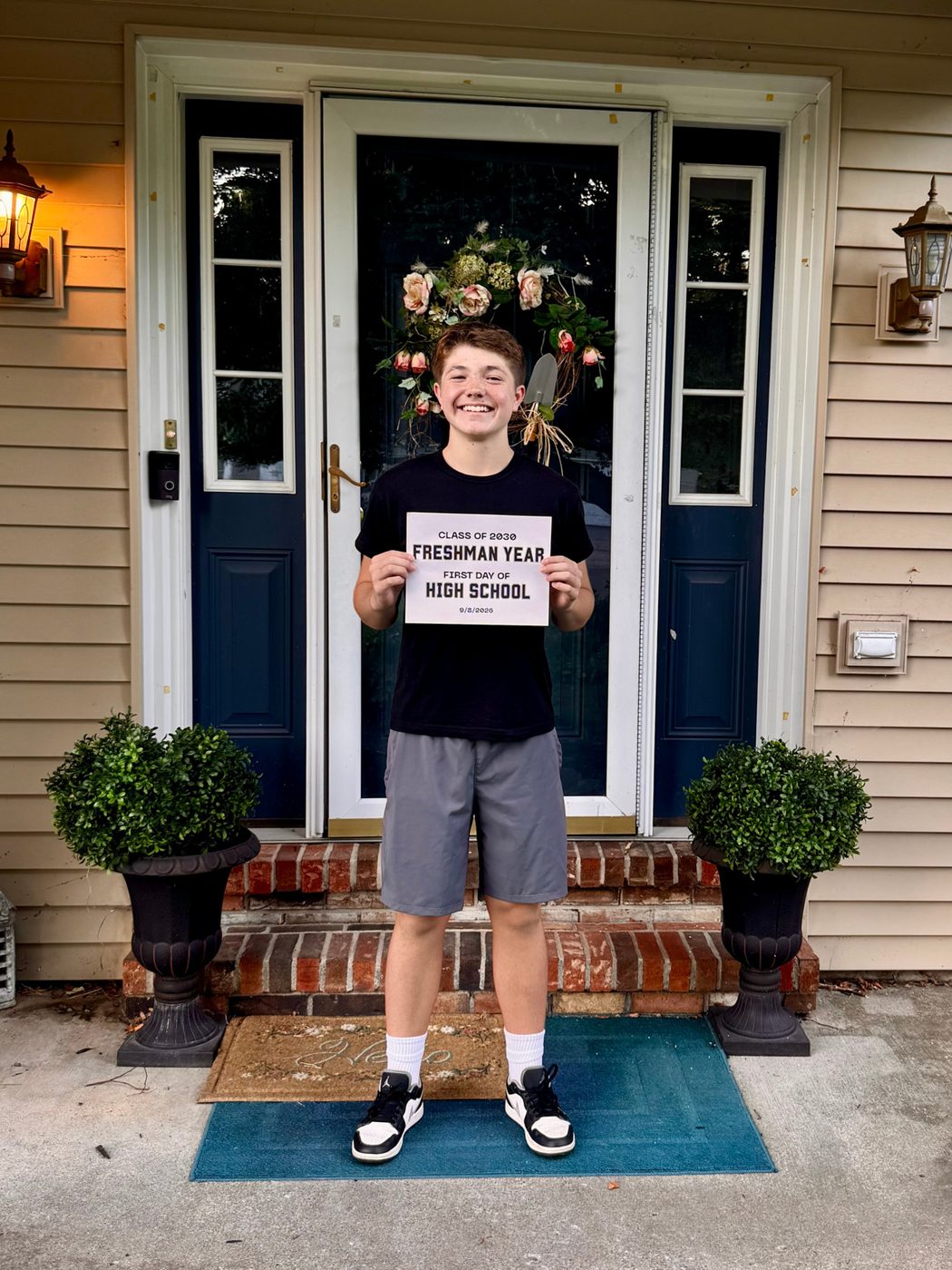 A first day of high school, holding a Freshman Year sign