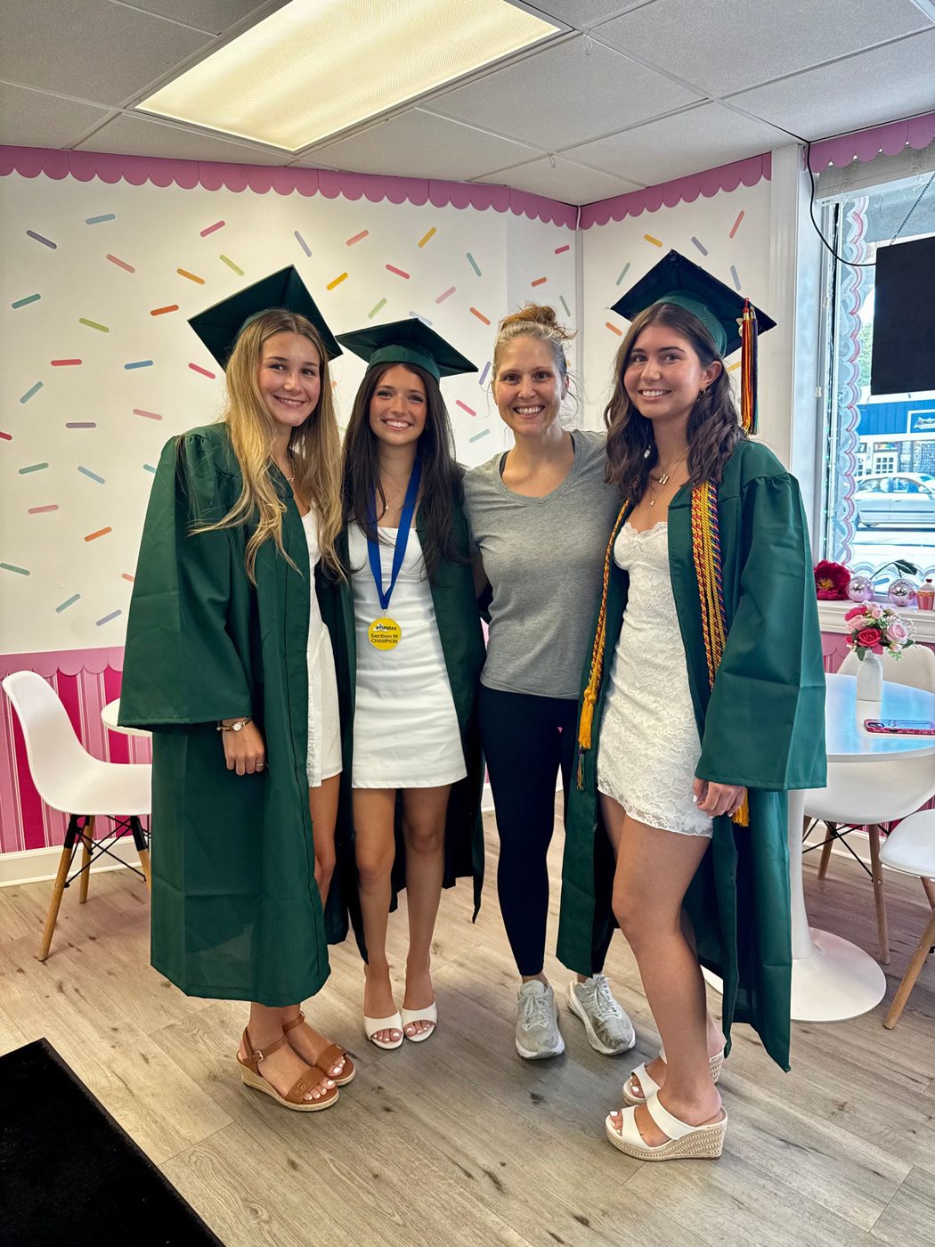 Mrs. Kelder with three graduates in the new shop under the sprinkle wall