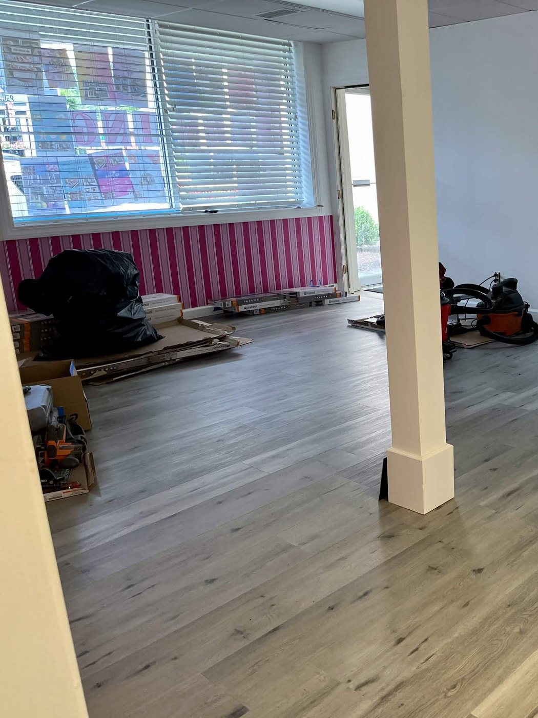 The new space part-way through the build, with the pink striped wall in and the plank floor going down